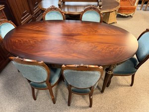 Oválny jedálenský stôl s výraznou kresbou dreva a sadou čalúnených stoličiek