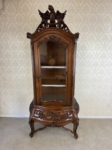 Presklená vitrína s bohatým rezbovaním, korpusom na esovitých nohách a vrcholovou sochou dvojhlavého orla