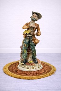 Porcelánová soška hudobníka s gitarou