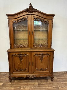 Dubová vitrína s vyrezávanými ornamentmi a sklenenými dvierkami